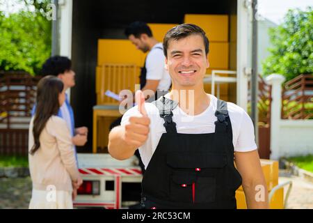 Ritratto sorridente dell'addetto alla consegna presso la sede dei clienti, dei clienti che ricevono la scatola dal corriere, degli addetti alla consegna soddisfatti che controllano l'ordine e lavorano con loro Foto Stock