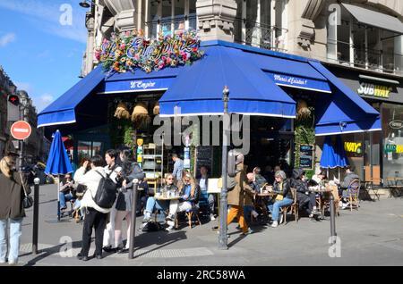 Parigi, Francia - 18 marzo 2023: Persone in un ristorante all'aperto animato in via del secondo distretto di Parigi, Francia. Foto Stock