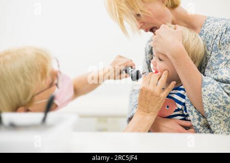 Bambino bambino bambino bambino in esame dal suo medico pediatra durante un controllo medico standard in presenza e comfort di sua madre. Sanità pubblica nazionale e cura dei bambini koncept Foto Stock