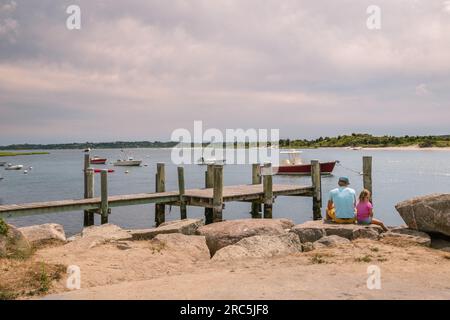 Menemsha, Chilmark, Martha's Vineyard, Massachusetts, US-luglio 26, 2022: Padre e figlia seduti vicino al molo che guardano l'oceano in un'iconica villa di pescatori Foto Stock