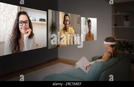 Donna che indossa un auricolare per realtà virtuale che partecipa a una videoconferenza a casa Foto Stock