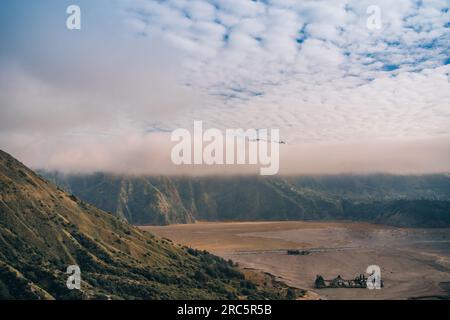 Incredibile vista panoramica del monte bromo con la scogliera nella nebbia. Nebbia mattutina nel Parco Nazionale di Semeru Foto Stock