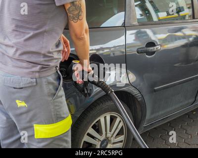 Cremona, Italia - 3 luglio 2023 donna di servizio caucasica presso la stazione di rifornimento di Eni Agip City che pompava benzina a un'auto del cliente Foto Stock