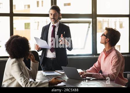 Un responsabile IT di mezza età ha un incontro di lavoro con i colleghi Foto Stock