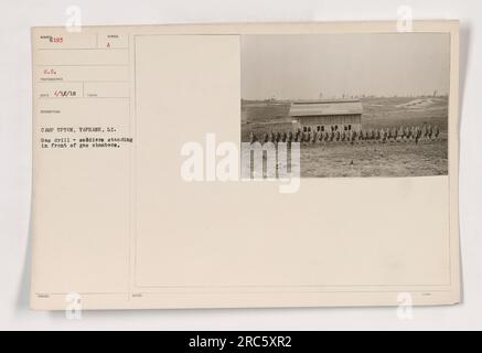 Soldati a Camp Upton, Long Island, che partecipano a un'esercitazione con maschera a gas. Durante questo esercizio di formazione, sono visibili in piedi di fronte alle camere a gas. Questa fotografia, scattata l'11 aprile 1918, serve come documentazione delle attività svolte nel campo durante la prima guerra mondiale. Nota: Il numero della fotografia è 6198 nella serie. Foto Stock