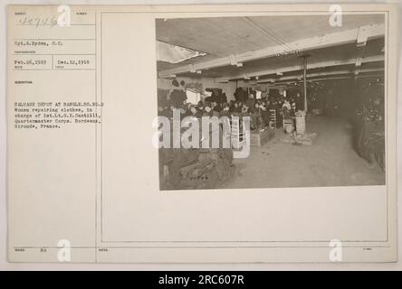 Donne che lavorano al Salvage Depot di Bangle, Bordeaux, Francia durante la prima guerra mondiale Sono mostrati come riparare gli indumenti sotto la supervisione del 1° tenente G.E. Santilli del Quartermaster Corps. Fotografia scattata il 12 dicembre 1918 dal Sgt. G. Ryden. Foto Stock