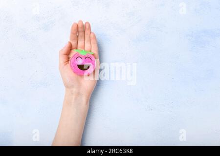 Sfera di sollecitazione con impugnatura femmina con faccia felice disegnata su sfondo chiaro Foto Stock