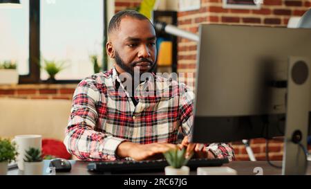 Dipendenti che si concentrano sullo svolgimento di importanti mansioni lavorative, lavorando in remoto da un elegante ufficio personale. Si è inventato un telelavoratore che scriveva sulla tastiera del computer, primo piano Foto Stock