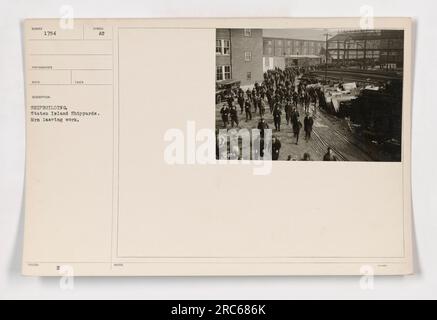 I lavoratori dei cantieri navali di Staten Island lasciano il lavoro, durante la prima guerra mondiale. Questa fotografia cattura la vivace attività e il lavoro coinvolto nella costruzione navale, una parte essenziale degli sforzi militari americani durante la guerra. Foto Stock
