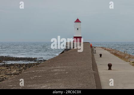 Il semplice faro dipinto di rosso e bianco a Berwick-on-Tweed, alla fine del molo Foto Stock