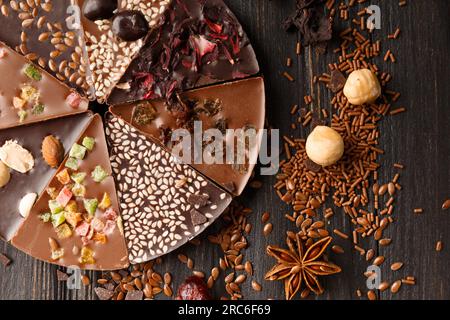 Composizione creativa cioccolato a forma di pizza con canditi, noci, frutti secchi, pizza al cioccolato e ingredienti Foto Stock