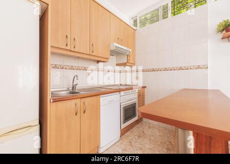 Una piccola cucina di un appartamento loft con piccole finestre alte sulla parete Foto Stock