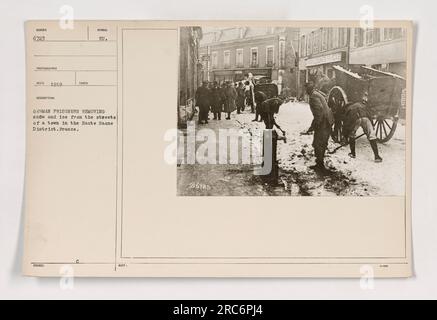 Soldati americani che aiutano a liberare neve e ghiaccio dalle strade di una città nel distretto dell'Haute Saone, in Francia. La fotografia è stata scattata nel 1919 e mostra i soldati che supervisionano i prigionieri tedeschi nel compito. Foto Stock