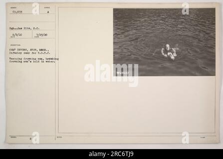 I soldati a Camp Devens, Ayer, Massachusetts, dimostrano un'esercitazione salvavita durante l'addestramento R.O.T.C. L'immagine cattura un soldato che salva un uomo annegato e rompe la presa dell'uomo annegato nell'acqua. La fotografia è stata scattata il 23 luglio 1920 e ha il numero di identificazione 69.033." Foto Stock