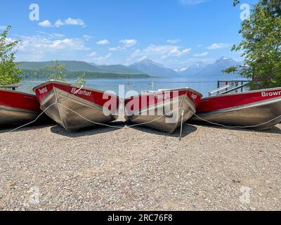 West Glacier, MT USA - 20 maggio 2023: Barche allineate sullo splendido lago McDonald nel Glacier National Park a West Glacier in Montana in una giornata nebbiosa. Foto Stock