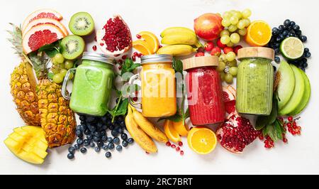 Frullati di frutta e verdura fresca o succo con vari ingredienti su sfondo leggero. Vista dall'alto Foto Stock