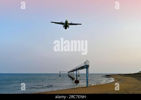 Lanzarote, Isole Canarie, città di Arrecife, parte inferiore dell'aeroporto e luci di atterraggio, mentre un aereo passeggeri a due motori atterra con il cielo blu rosso serale Foto Stock