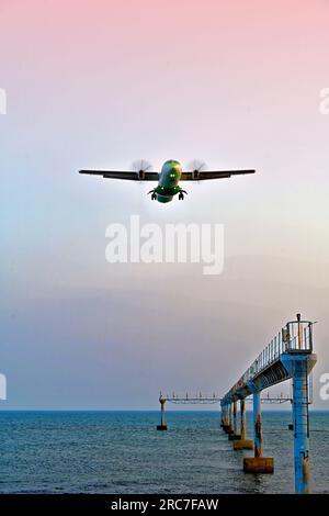 Lanzarote, Isole Canarie, città di Arrecife, parte inferiore dell'aeroporto e luci di atterraggio, mentre un aereo passeggeri a due motori atterra con il cielo blu rosso serale Foto Stock