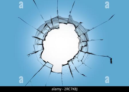 Un grande buco nel cielo blu. Incrinature sul finestrino dovute alla rottura Foto Stock