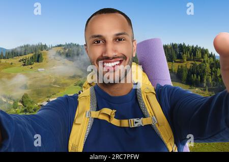 Buon turista con zaino che scatta selfie in montagna Foto Stock