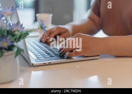 Donna che sta scrivendo su un computer portatile con tastiera che cerca informazioni da vicino sulla tastiera. tecnologia digitale, comunicazione online, lavoro da ho Foto Stock
