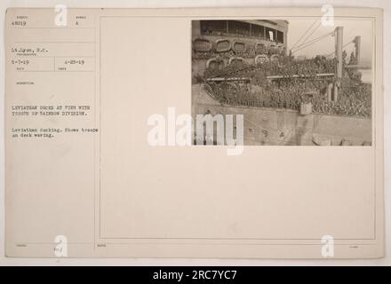 Il Leviatano ormeggia a un molo con truppe della Divisione Arcobaleno. La fotografia, scattata il 25 aprile 1919, dal tenente Lyon, S.C., mostra le truppe che saltano sul ponte. Questa immagine è stata ricevuta il 7 maggio 1919 ed è etichettata con la descrizione "Leviathan Docks at Pier with Troops of Rainbow Division". Foto Stock