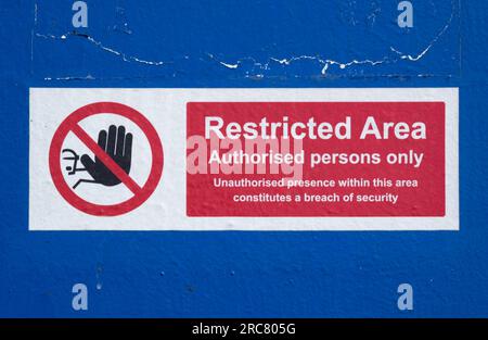 Cartello di divieto di accesso rosso e bianco, solo persone autorizzate, con icona a mano, su sfondo metallico verniciato blu Foto Stock