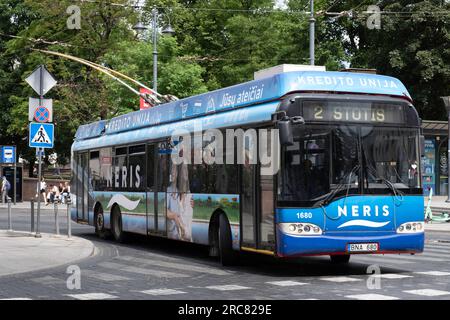 Autobus Blue Trolley con pubblicità ai lati in una strada di Vilnius, Lituania. Trasporti pubblici Foto Stock