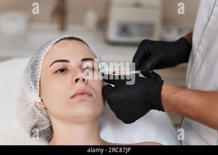 la donna riceve un'iniezione cosmetica di botox in faccia. Foto Stock