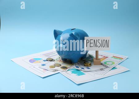 Risparmi pensionistici. Salvadanaio, contanti e grafici su sfondo azzurro Foto Stock