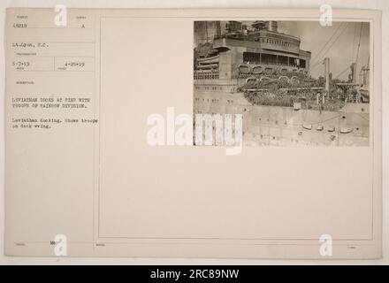 Leviathan, una nave militare, ormeggia a un molo con truppe della Divisione Arcobaleno a bordo. Le truppe possono essere viste sul ponte salutare. Questa foto è stata scattata da S.C. Lyon e ricevuto il 5-7-19. La descrizione è stata rilasciata il 4-25-19. La foto fa parte di una serie che documenta le attività militari americane durante la prima guerra mondiale. Foto Stock