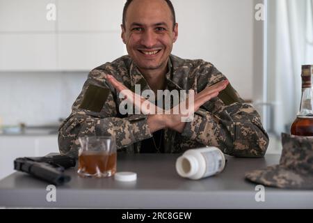 Ritratto di un militare di mezza età che guarda la macchina fotografica con un sorriso, durante la sessione di terapia. Soldato disabile che soffre di depressione, psicologico Foto Stock