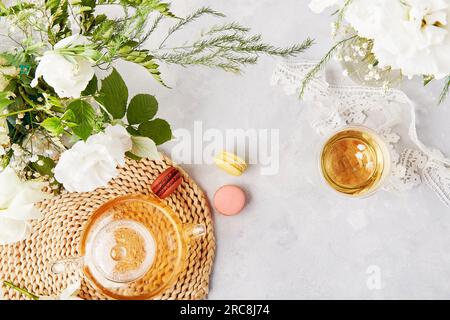 Tempo femminile e meditativo per te stesso. Tazza di tè alle erbe, dessert a base di macaroon, stile di vita piatto. Copia spazio. Foto Stock