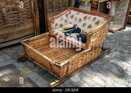 Diportisti di paglia su una tradizionale slitta di cesto di vimini a Monte Funchal, isola di Madeira, Portogallo Foto Stock