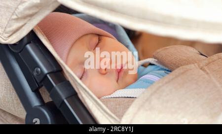 La bambina si addormenta durante la passeggiata nel parco cittadino Foto Stock