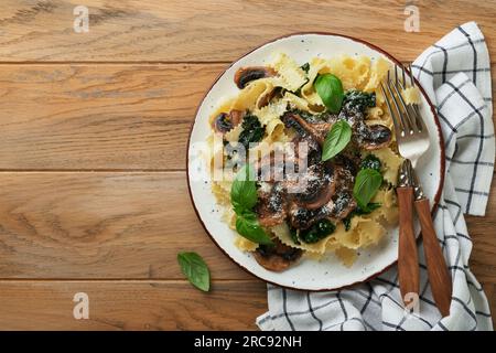 Cremosa pasta Alfredo. Fettuccini di pasta italiana con funghi, carne di pollo, spinaci, basilico e salsa di panna su fondo rustico antico. Traditiona Foto Stock