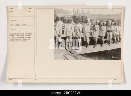 I lavoratori delle Malgache trasportano ghiaia dalle chiatte dei canali per costruire autostrade per il traffico di guerra dietro il fronte occidentale, in Francia. Questa foto, scattata nel 1919, mostra l'inadeguatezza della forza lavoro e le sfide che hanno affrontato per la costruzione di strade durante la prima guerra mondiale. Foto Stock