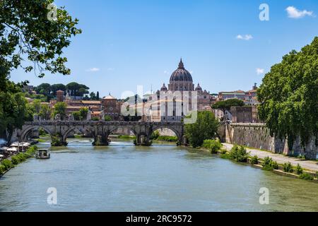 Vista lungo il fiume Tevere fino a Ponte Sant'Angelo, con la cupola di San Basilica di Pietro sullo sfondo, a Roma, regione Lazio, Italia Foto Stock