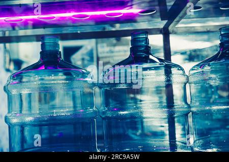 Fabbrica di acqua delle bevande utilizzando il sistema di sterilizzazione della disinfezione della luce UV nella linea di produzione per pulire il serbatoio della bottiglia di acqua potabile Foto Stock