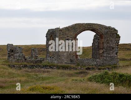 I resti in rovina della chiesa di St Dwynwen sull'isola di Llanddwynn, Anglesey Foto Stock