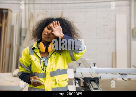 Donne stanche lavoratrici di fabbrica. donna ingegnere esausta sudore. lavoro faticoso e duro lavoro di donne africane nere che lavorano. luogo di lavoro caldo Foto Stock