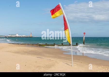 Middle Chine, Bournemouth, UK - 12 luglio 2023: RNLI Beach Flag con Bournemouth Pier sullo sfondo. Foto Stock