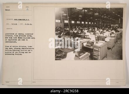 I soldati della Central Directory Division, Pier 86 a New York City sono visti impegnati in attività legate alla classificazione e all'invio della posta dei soldati alle sue destinazioni. La vista mostra la sezione amministrativa, la sezione indicizzazione e una parte della sezione archiviazione e reindirizzamento. Questa foto è stata scattata il 25 giugno 1919, con il fotografo S.C. Stemizer. Il numero assegnato a questa fotografia è 58512. Foto Stock