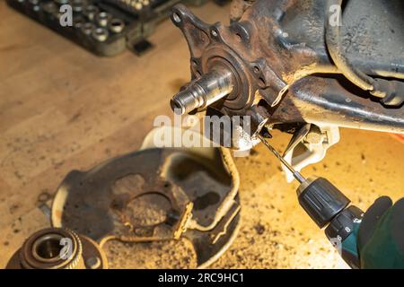 Il meccanico dell'auto esegue una filettatura. Riparare il cuscinetto del mozzo ruota. Officina. Foto Stock