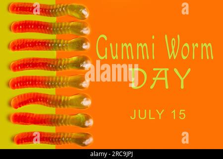 Vermi Gummi su sfondo colorato con testo: 'Giorno del verme Gummi. 15 luglio" Foto Stock