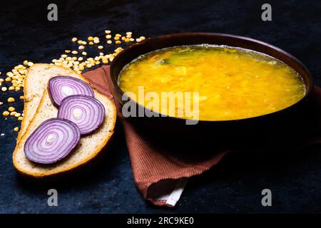 Appetitosa zuppa di piselli caldi e cipolla servita con fette di pane Foto Stock