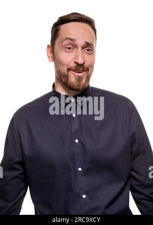Ritratto di un uomo bello e non rasato, vestito con una camicia blu scuro, in piedi su uno sfondo bianco. Uomo sicuro di sé. Foto Stock