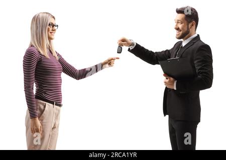 Uomo d'affari che dà le chiavi della macchina a una giovane donna isolata su sfondo bianco Foto Stock