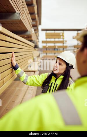 Lavoratrice che esamina le tavole con un collega del settore Foto Stock