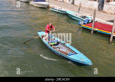 Vista dall'alto di un uomo anziano che canta in stile veneziano sul canale Rio della Misericordia in estate, Cannaregio, Venezia, Veneto, Italia Foto Stock